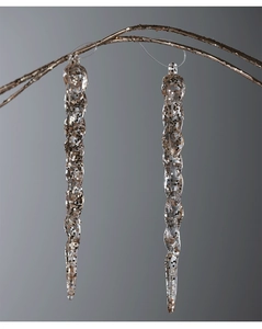 Macro detail of two spiral acrylic icicles with gold glitter hanging on festive branches