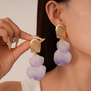 Detail of matte gold studs and double-layer purple gradient acrylic petal earrings