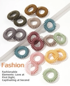 Macro detail of elastic spiral hair ties in various Morandi and candy colors for women