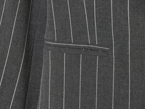 Détail macro du tissu gris foncé à rayures fines montrant la couture de la poche