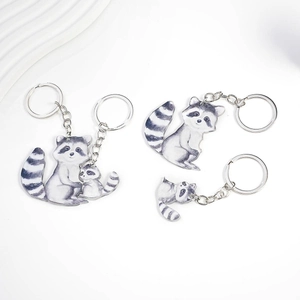 Detail of creative raccoon couple keychains featuring realistic sketches on acrylic