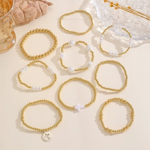 Dettaglio del set di 9 braccialetti elastici con perline dorate, perle e ciondoli a croce