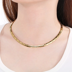 Close-up of gold stainless steel choker collar with delicate cross pattern texture