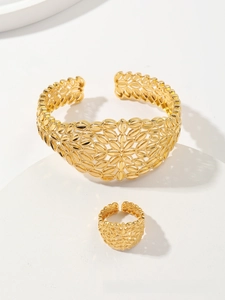 Detailed view of hollow leaf pattern gold-plated bridal bracelet and ring jewelry set