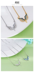 Detail of angel wing pendants in gold and silver finish with blue and white zircon inlays