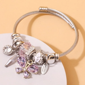 Silver cable cuff bracelet featuring purple butterfly crystals and faceted charms