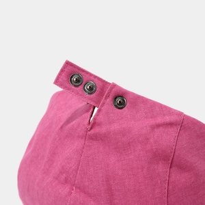 Detail of pink cotton newsboy hat featuring three adjustable textured metal press studs