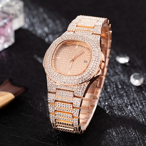 Macro shot of rose gold iced-out quartz watch with date display on black background