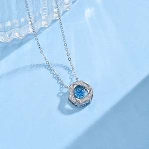 Macro view of sterling silver snowflake pendant with dancing blue zircon stone