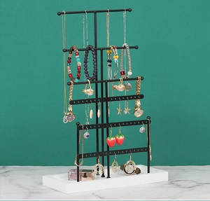 Detail of 6-tier black metal jewelry organizer with white base for necklaces and earrings