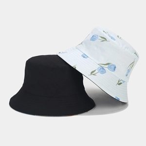 Détail de bobs réversibles en coton, noir uni et motif floral de tulipes bleues