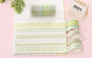 Detail view of 6 rolls of green and yellow plaid washi tape used in a notebook journal