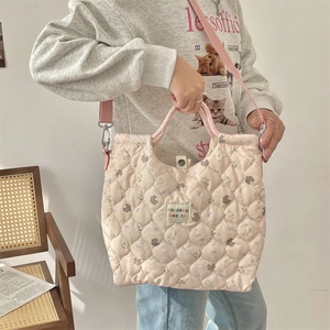 Detail of pink quilted tote bag with cute cartoon prints and functional drawstring closure