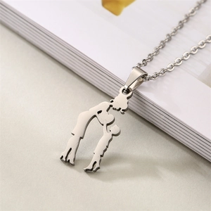 Detail shot of silver stainless steel pendant showing mother kissing child silhouette