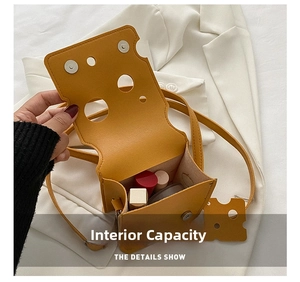 Mini yellow cheese shaped crossbody bag showing internal storage space for cosmetics