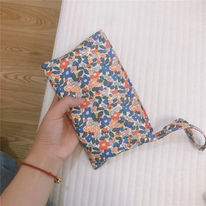 Dettaglio della mini borsa in cotone a fiori con cinturino da polso per accessori