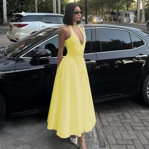 Detail des tiefen V-Ausschnitts und Neckholders an diesem leuchtend gelben Sommerkleid