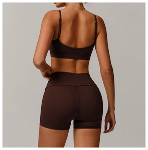 Detail of cross-back yoga bra and high-waisted shorts in dark chocolate stretch fabric