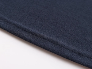 Macro detail of navy blue knit fabric with precise double-needle stitching and texture