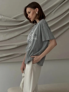 Detail of grey cotton T-shirt featuring a decorative pearl necklace print on the chest