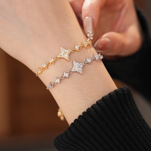 Close-up of star bracelets with zircon inlay in gold and silver finish on wrist