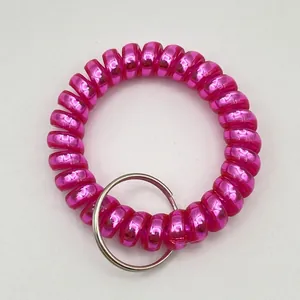 Close-up of a pink spiral telephone wire wristband with a silver metal key ring