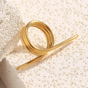 Detailaufnahme des 18K vergoldeten Spiralrings auf einer Basis aus Naturstein