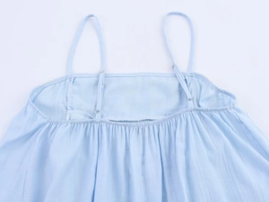 Close-up of light blue camisole showing elastic pleats and adjustable thin straps