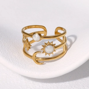 Macro detail of gold celestial multi-layer ring with sun moon stars and white shell inlay