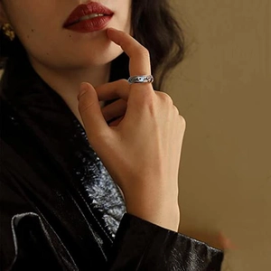 Minimalist spinning stainless steel moon and star ring shown on a finger in retro style