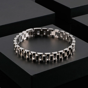 Macro shot of silver stainless steel watch-style bracelet links on black geometric base