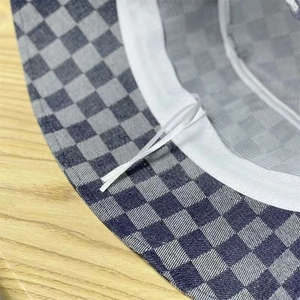Detail shot of denim checkerboard bucket hat showing inner lining and adjustable drawstring