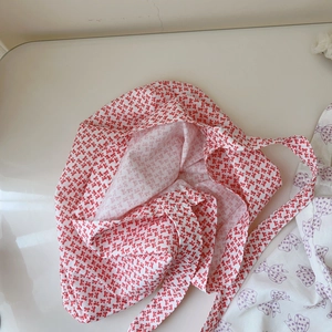 Vue détaillée du motif de nœud rouge et blanc sur le sac bandoulière léger en coton