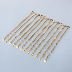 Detail of multiple 18k gold plated stainless steel initial letter pendant bracelets