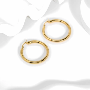 Macro shot of 18k gold plated stainless steel hollow hoop earrings on white background