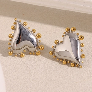 Detailed macro view of two-tone heart stud earrings with gold beaded edges and silver finish