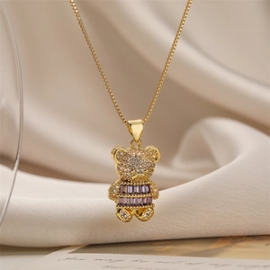 Macro shot of teddy bear pendant necklace with purple gemstone and crystals in gold finish
