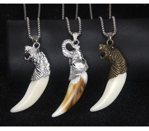 Detailed view of wolf tooth pendant necklaces in silver and bronze finish with chains