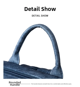Detail showing the ergonomic rounded top handle of the blue denim backpack for travel