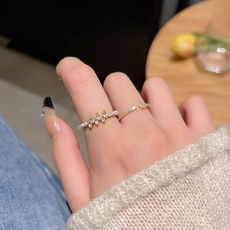 Close-up of gold-plated open rings with white zircon stones on model's hand