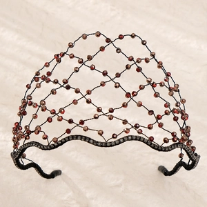 Detailed close-up of woven mesh headband with reddish-brown beads and dark rhinestones