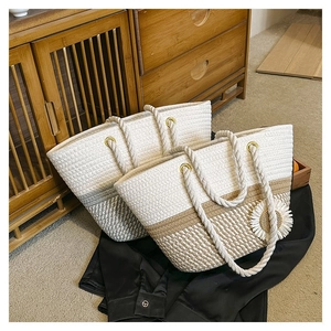 Close-up of woven tote bags with flower accents in cream and khaki straw material