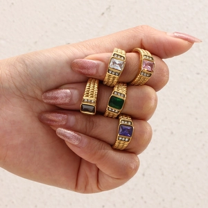Five gold braided stackable rings featuring colorful rectangular zircons on hand