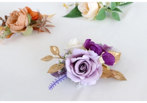 Detailed view of handmade purple rose wrist corsage with golden leaves for weddings