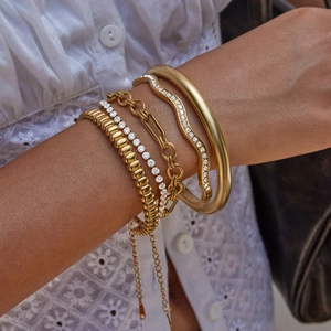 Détails de bracelets superposés en or 18k comprenant des styles tennis et chaînes