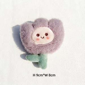 Détail d'une tulipe en peluche violette avec visage souriant brodé mesurant 9x8 cm