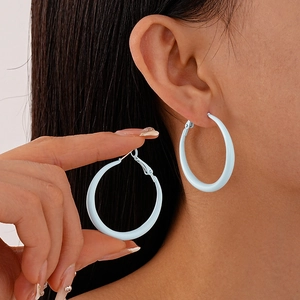 Detail of light blue hoop earrings shown on a model for a stylish minimalist look