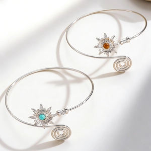Detail of vintage sun arm cuff featuring starburst motif and turquoise stone inlay