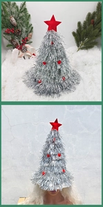 Close-up of silver tinsel Christmas tree hat with red star topper and pom-poms details