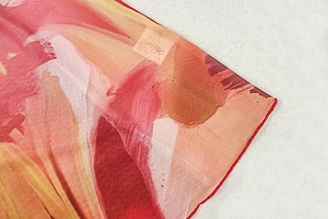 Detailed view of lightweight printed fabric with artistic dye pattern and size S label